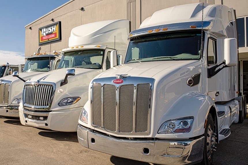 Peterbilt and International trucks in front of Rush Truck Leasing building